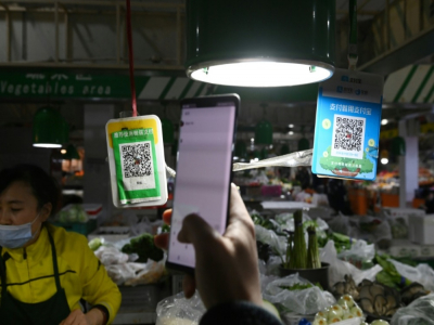 Un client scanne un code QR pour payer ses achats dans un marché de Pékin, le 27 octobre 2020 - GREG BAKER [AFP]