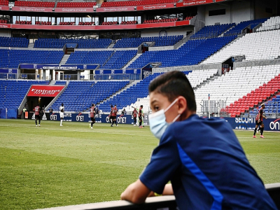Un ramasseur de balle masqué lors d'un match amical entre Lyon et Nice, le 4 juillet 2020 au Groupama Stadium à Décines-Charpieu - JEFF PACHOUD [AFP/Archives]