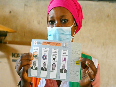 Une femme montre un bulletin de vote pour la présidentielle, le 31 octobre 2020 à Abobo, un quartier populaire d'Abidjan, en Côte d'Ivoire - Issouf SANOGO [AFP]