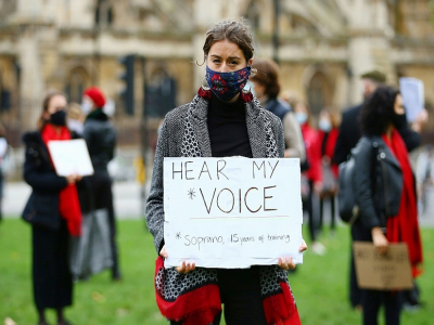 Une manifestante, chanteuse d'opéra, tient une pancarte "Entendez ma voix", le 30 octobre 2020 à Londres - Hollie Adams [AFP]