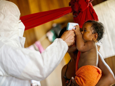 Un infirmier prend la température d'un enfant à Igarape-Miri, le 28 octobre 2020 au Brésil - TARSO SARRAF [AFP]