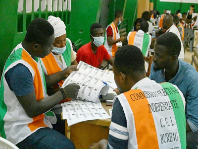 Des membres de la Commission électorale ivoirienne vérifient les listes de votants pendant le comptage des voix, le 31 octobre 2020 à Abidjan - Issouf SANOGO [AFP]