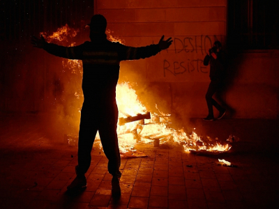 Un manifestant devant un feu de barricades lors d'une manifestation à Barcelone le 31 octobre 2020 - Josep LAGO [AFP]
