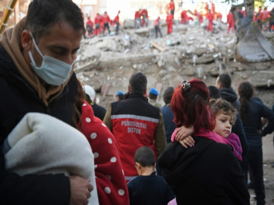 Des proches de personnes encore sous les décombres attendent, le 1er novembre 2020, devant un des immeubles détruits par le puissant séisme de l'avant-veille - OZAN KOSE [AFP]