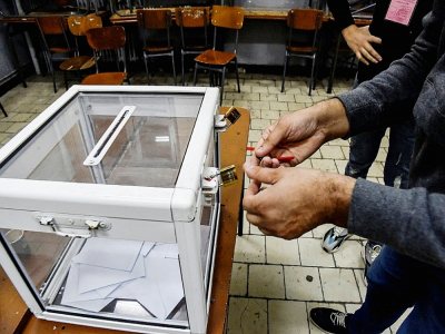 Des assesseurs ouvrent une urne utilisée lors du référendum sur la réforme de la Consitution algérienne à Alger, le 1er novembre 2020 - RYAD KRAMDI [AFP]