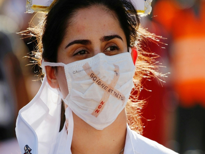 Une soignante portant un masque avec l'inscription "Soigne et tais-toi, non" pendant une manifestation à Berne le 31 octobre 2020 - STEFAN WERMUTH [AFP]