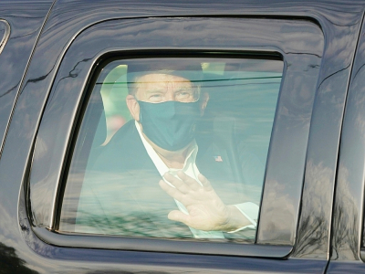 Le président américain Donald Trump salue ses symathisants depuis la limousine présidentielle lors d'une brève sortie de l'hôpital militaire de Walter Reed à Bethesda, près de Washington, le 4 octobre 2020 - ALEX EDELMAN [AFP]
