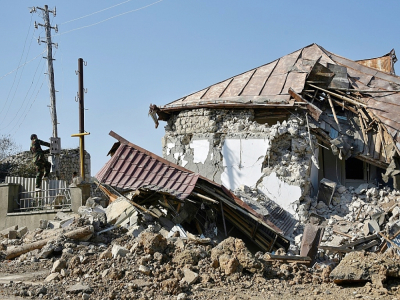 Un homme répare des câbles électriques endommagés à côté d'une maison détruite par un bombardement, le 1er novembre 2020 à Choucha, en Azerbaïdjan - Karen MINASYAN [AFP/Archives]