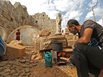 Un déplacé syrien entretient son feu de bois le 1er novembre 2020 dans le temple romain d'al-Baqirah, dans le nord-ouest de la Syrie, où il a installé sa famille - Abdulaziz ketaz [AFP]