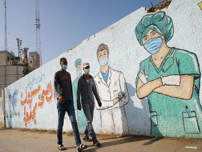 Des soignants masqués sur une fresque murale à Khan Younes dans la bande de Gaza le 12 novembre 2020 - Mohammed ABED [AFP]