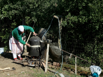 Vitore Lufi distille le raki, une eau de vie, dans son jardin de Fishtë, le 20 octobre 2020 en Albanie - Gent SHKULLAKU [AFP]