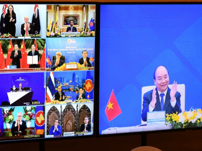 Le Premier ministre vietnamien Nguyen Xuan Phuc (à droite sur l'écran) se félicite de l'accord signé par 15 pays, le 15 novembre 2020, à HanoÏ - Nhac NGUYEN [AFP]