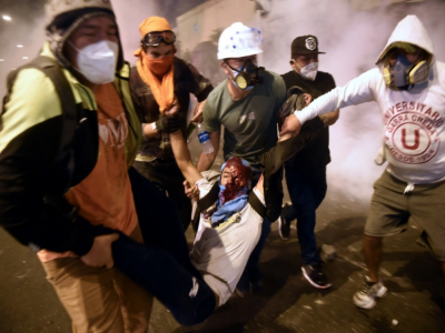 Des manifestants portent un blessé lors de heurts avec la police lors d'un rassemblement de soutien au président Vizcarra, le 14 novembre 2020 à Lima, au Pérou - ERNESTO BENAVIDES [AFP]