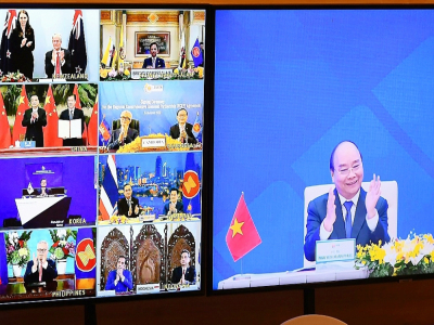 Le Premier ministre vietnamien Nguyen Xuan Phuc (d) applaudit l'accord signé par 15 pays de l'Asean, le 15 novembre 2020, à HanoÏ - Nhac NGUYEN [AFP]