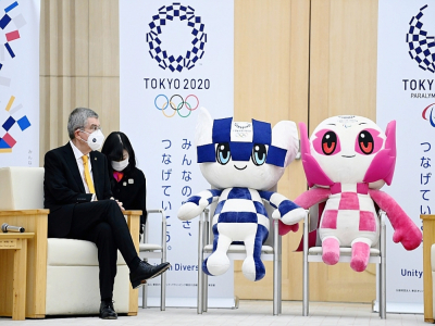 Le président du Comité international olympique (CIO), Thomas Bach, assis à côté des mascottes des Jeux olympiques et paralympiques de Tokyo-2020, reportés en 2021, le 16 novembre 2020 à Tokyo - CHARLY TRIBALLEAU [AFP]