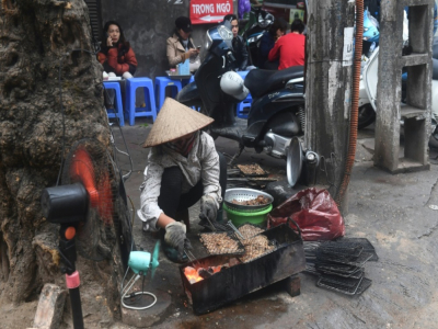 Une vendeuse de rue prépare un "bun cha", une soupe à base de nouilles et de porc grillé, en janvier 2018 à Hanoï, au Vietnam - HOANG DINH NAM [AFP]