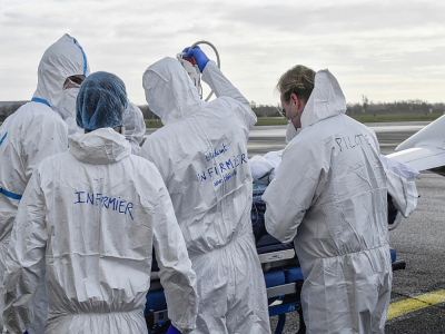 Une équipe médicale entoure un brancard occupé par un malade du Covid-19, le 16 novembre 2020 sur le tarmac de l'aéroport de Bron, près de Lyon - Philippe DESMAZES [POOL/AFP]