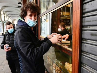 Un client portant un masque commande un café à Turin (Italie), le 17 novembre 2020. - MIGUEL MEDINA [AFP]