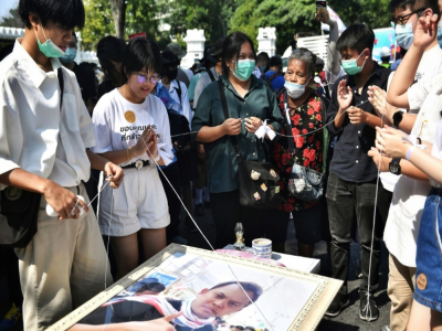 Des élèves autour du portrait du ministre de l'Education thaïlandais, lors d'une manifestation pro-démocratie à Bangkok - Lillian SUWANRUMPHA [AFP]