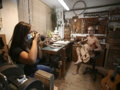 Christian Magdeleine, luthier pose nu avec une guitare en fabrication, devant la photographe Caroline Gilles, à Bastia le 19 novembre 2020 pour alarmer sur son "agonie" - Pascal POCHARD-CASABIANCA [AFP]