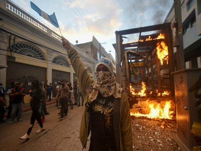 Des manifestants paradent devant un abribus incendié, dans la capitale du Guatemala, le 21 novembre 2020. - Orlando  ESTRADA [AFP]