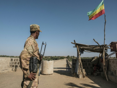 Un combattant amhara monte la garde au passage frontalier avec l'Erythrée, marqué par un drapeau impérial éthiopien à Humera, dans la province dissidente du Tigré, le 22 novembre 2020 - EDUARDO SOTERAS [AFP]