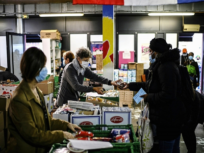 Des bénévoles des Restos du coeur distribuent une aide alimentaire à des personnes dans le besoin, le 13 octobre 2020 à Paris - Christophe ARCHAMBAULT [AFP/Archives]