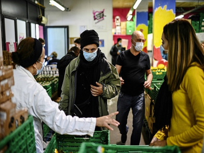 Des bénévoles des Restos du coeur distribuent une aide alimentaire à des personnes dans le besoin, le 13 octobre 2020 à Paris - Christophe ARCHAMBAULT [AFP/Archives]