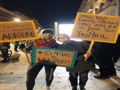 Deux manifestantes brandissent leurs pancartes contre la loi Sécurité globale. - Justine Tariel