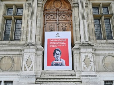 Une banderole portant le portrait de la chercheuse franco-iranienne emprisonnée en Iran, Fariba Adelkah, est suspendue sur la façade de l'Hôtel de ville à Paris le 5 juin 2020 - BERTRAND GUAY [AFP]