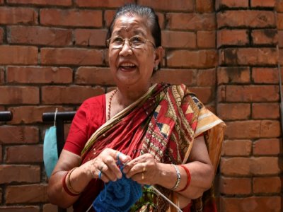 Champa Devi Tuladhar tricote pendant une interview avec l'AFP, le 6 août 2020 à Katmandou, au Népal - PRAKASH MATHEMA [AFP]