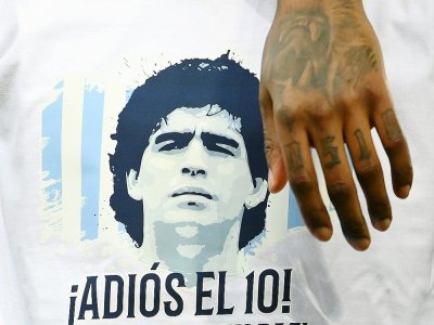 Le portrait de l'Argentin Diego Maradona, décédé le 25 novembre, est affiché sur un T-shirt, porté par un joueur du Paris Saint-Germain, avant le début du match de L1 contre Bordeaux, le 28 novembre 2020 au Parc des Princes - FRANCK FIFE [AFP]