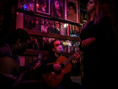 La chanteuse Claudia Picado (d), les guitaristes Pedro Dias (g) et Carlos Vicoso (c) à la maison de fado "Tasca do Chico", dans le quartier du Bairro Alto, le 12 novembre 2020 à Lisbonne - PATRICIA DE MELO MOREIRA [AFP]