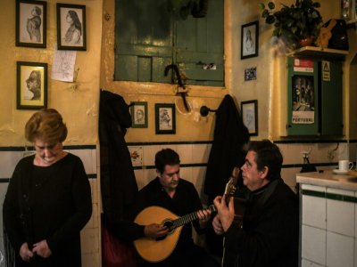 La chanteuse Fernanda Proenca (g) et les guitaristes Paulo Silva (c) et Ze Simoes à la maison de fado "A Baiuca", dans le quartier de l'Alfama, le 27 novembre 2020 à Lisbonne - PATRICIA DE MELO MOREIRA [AFP]