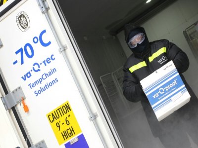 Un employé de l'entreprise allemande Va-Q-Tec porte un conteneur de glace sèche, le 1er décembre 2020 à Wurzburg - Daniel ROLAND [AFP]