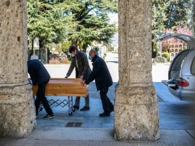 Des employés des pompes funèbres portent un cercueil dans un cimetière de Bergame, en Italie, en mars 2020 - Piero Cruciatti [AFP/Archives]