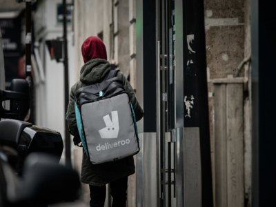 Un livreur pour la plateforme Deliveroo cherche une adresse à Paris, le 8 mars 2020 - Philippe LOPEZ [AFP]