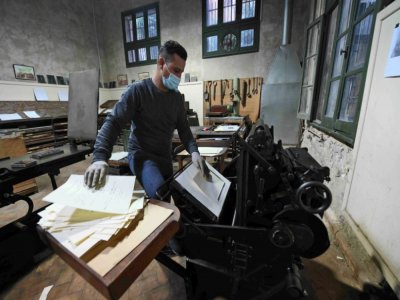 Un employé utilise une machine imprimant des caractères de plomb frappés de signes hiéroglyphes dans l'atelier typographique de l'Institut français d'archéologie orientale, le 10 décembre 2020 au Caire - Ahmad HASSAN [AFP]