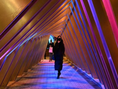 Des passants admirent l'oeuvre lumineuse "Iceberg", pendant le festival de "Luminothérapie", le 18 décembre 2020 à Montréal, au Canada - Eric THOMAS [AFP]