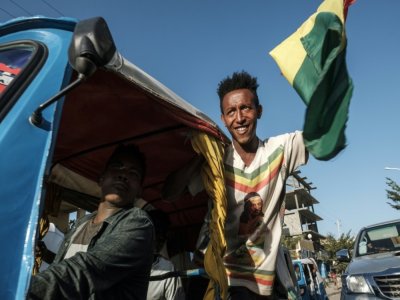 Un homme brandit un drapeau éthiopien penedant la célébration de la libération de  prisooniers du Front de libération du peuple du Tigré à Alamata le 10 décembre 2020 - EDUARDO SOTERAS [AFP]