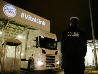 Un douanier français observe un camion arrivant du Royaume-Uni dans le terminal du tunnel sous la manche à Coquelles, le 1er janvier 2021 - Lewis Joly [POOL/AFP]