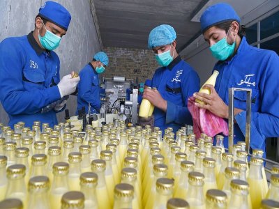 Des employés remplissent des bouteilles de lait dans l'entreprise Milko à Kandahar, le 30 septembre 2020 - WAKIL KOHSAR [AFP]