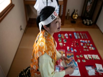 Kyoko Ishikawa montre sa collection de souvenirs olympiques dans sa résidence de Tokyo, le 18 décembre 2020 - Philip FONG [AFP/Archives]