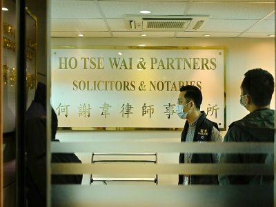 La police dans les bureaux de l'ex-avocat pro-démocratie Albert Ho, après qu'une cinquantaine de figures de l'opposition ont été arrêtées, à Hong Kong le 6 janvier 2021 - Peter PARKS [AFP]