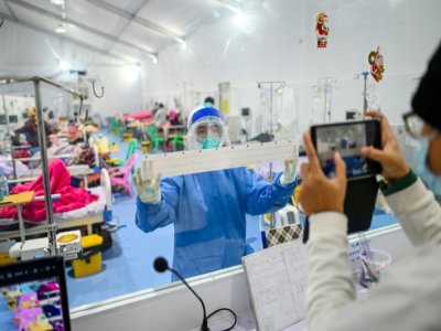 Des médecins s'occupent de patients atteints du Covid-19 dans l'unité de soins intensifs au centre Ayeyarwady, un hôpital de campagne édifié sur un stade de Rangoun, le 1er janvier 2021 en Birmanie - Ye Aung THU [AFP]