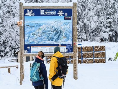 Des personnes regardent la carte du domaine skiable de Villard-de-Lans, le 5 janvier 2021 en Isère - Philippe DESMAZES [AFP]