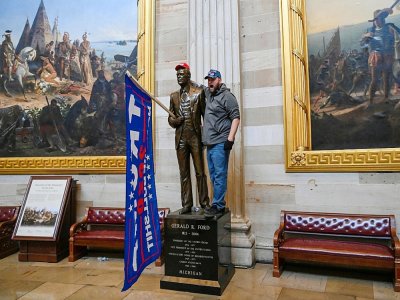 Un partisan de Donald Trump a placé un drapeau en faveur du président sortant sur une statue de la rotondedu Capitole, le 06 janvier 2021 - Saul LOEB [AFP]
