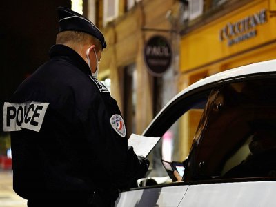 Un policier vérifie une attestation le 5 janvier 2021 à Metz, placé sous couvre-feu à partir de 18h00 - JEAN-CHRISTOPHE VERHAEGEN [AFP/Archives]