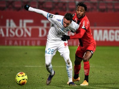 L'attaquant de Marseille, Florian Thauvin (g), aux prises avec le défenseur congolais de Dijon, Glody Ngonda, lors du match de Ligue 1 à Dijon, le 9 janvier 2021 - JEFF PACHOUD [AFP]