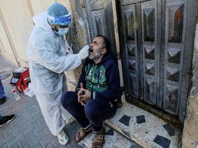 Un membre des services de santé palestiniens effectue des prélèvements biologiques pour des tests de coronavirus à Rafah, dans le sud de la bande de Gaza, le 11 janvier 2021 - SAID KHATIB [AFP]